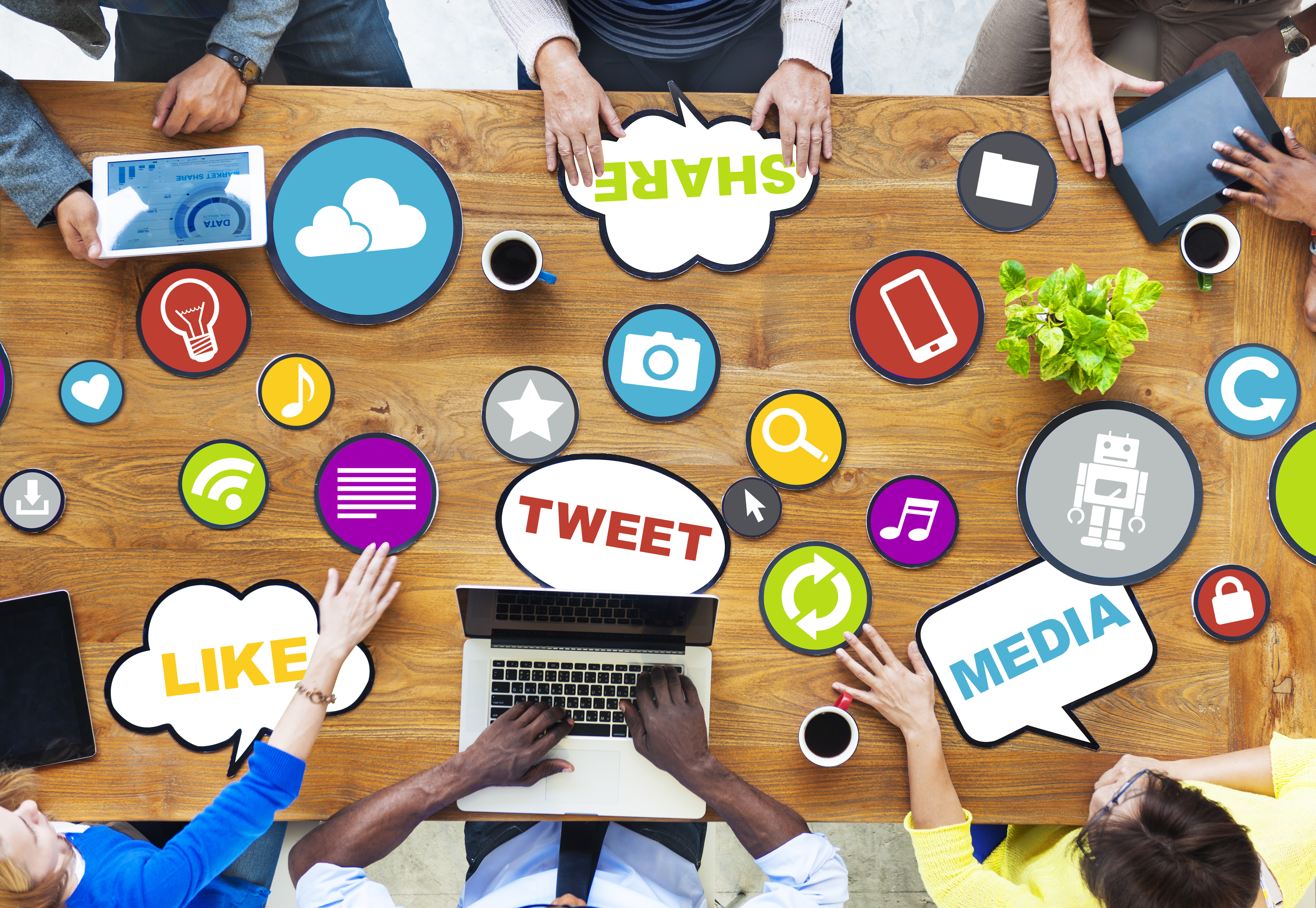 overhead shot of a team of people working with computers on social media sites